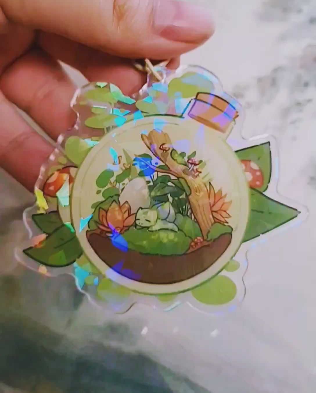 A short video showing the broken glass holographic effect in the keychain's arcrylic resin.